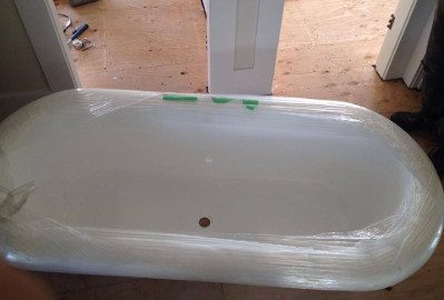 A clawfoot bathtub fully shrink-wrapped for moving