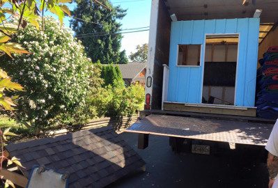 A kids' playhouse being lifted on the truck's tail lift